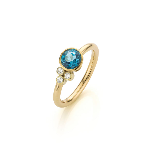 Asymmetrische ring met London Blue Topaas en diamant clustertje